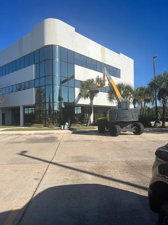High-rise commercial exterior painting from a boom lift on an office building