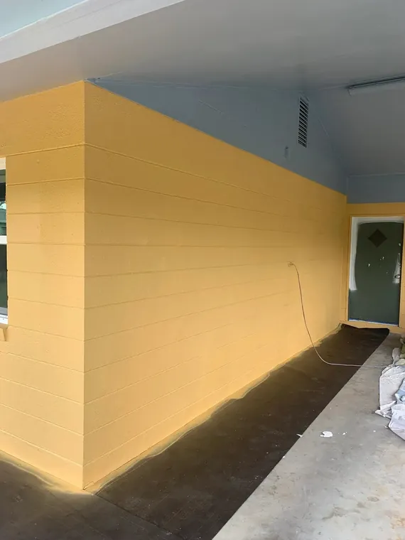 Exterior repaint of a concrete-block home in warm gold