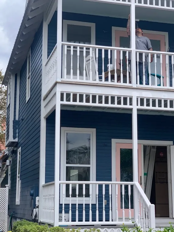 Exterior repaint of a navy two-story coastal home with white railings