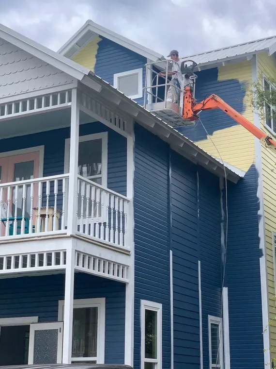 Exterior color change to navy on a coastal home, painted from a boom lift